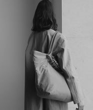 Load image into Gallery viewer, Nylon I Pazar Tote XL I brown I plant dyed japanese nylon I from aside I black and white picture of a woman wearing the bag over her shoulder