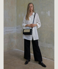Load image into Gallery viewer, The Vienna crossbody bag, size M in black from Italian calf leather. Long adjustable shoulder strap with signature hand knotted leather shoulder handle. This style is designed to fit all your essentials.