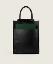 Load image into Gallery viewer, Pazar Magazine Tote Black I front view I showing the magazine pocket, the magazine and the signature braided handle I white background