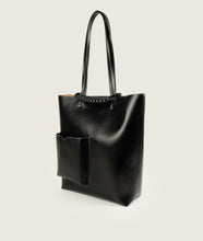 Load image into Gallery viewer, Pazar I Pazar Book Tote Grape Leather I Black with white Stitching I side view I showing the iconic closure system and the outside book pocket I also showing the even more stable straps I white background