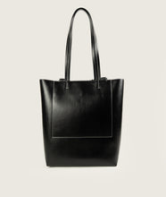 Load image into Gallery viewer, Pazar I Pazar Book Tote Grape Leather I Black with white Stitching I back view I showing the iconic closure system and the outside book pocket I also showing the even more stable straps I white background