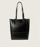 Load image into Gallery viewer, Pazar I Pazar Book Tote Grape Leather I Black with white Stitching I back view I showing the iconic closure system and the outside book pocket I also showing the even more stable straps I white background