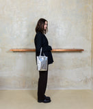 Load image into Gallery viewer, Pazar I Pazar Tote Nano Silver I silver I side view I showing iconic SAGAN closing system I model is wearing the bag at SAGAN Shop in Vienna