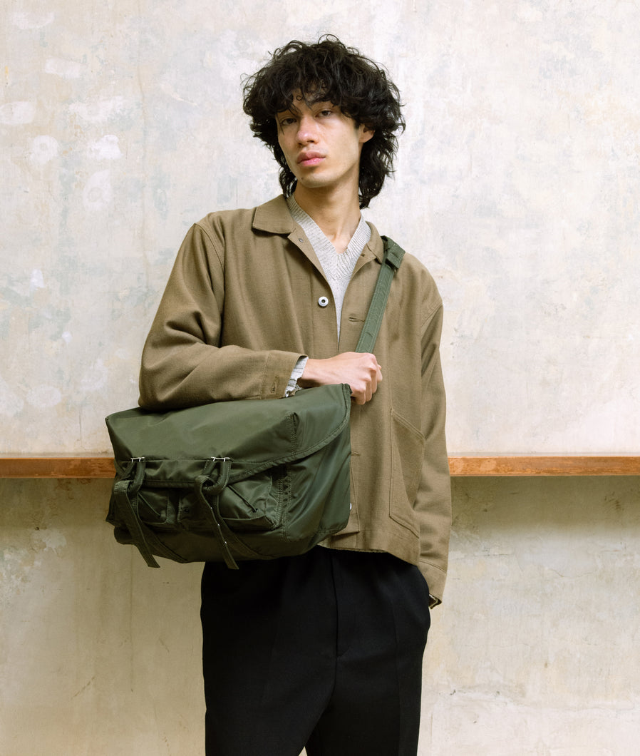 Nylon I Messenger Bag M Olive Green recycled Nylon I olive green I front view I man wearing the bag in front of his body in SAGAN Vienna Shop.
