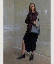 Load image into Gallery viewer, Gwyneth handbag, black, Size M, made from Italian smooth calf leather. The front plate is made from cow horn. Shoulder strap is adjustable and in the function of easy closing and opening the bag. 
